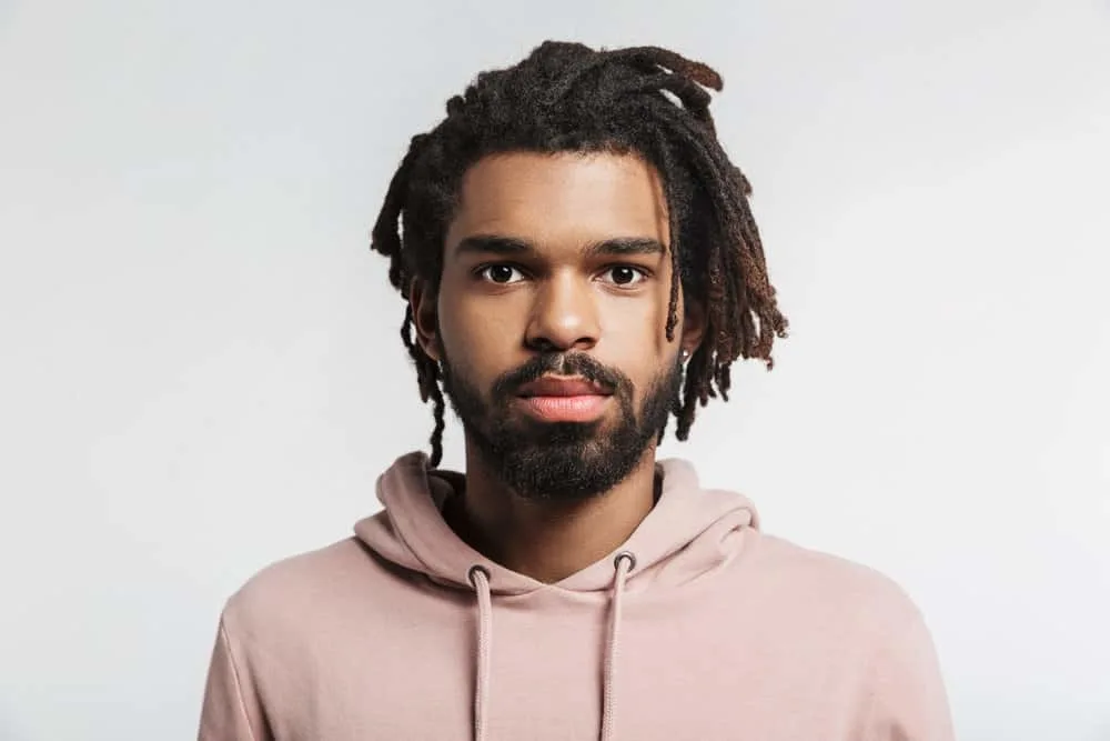 A 30-year-old black guy showing off the growth from his baby locs to mature dreads styled with coconut oil.