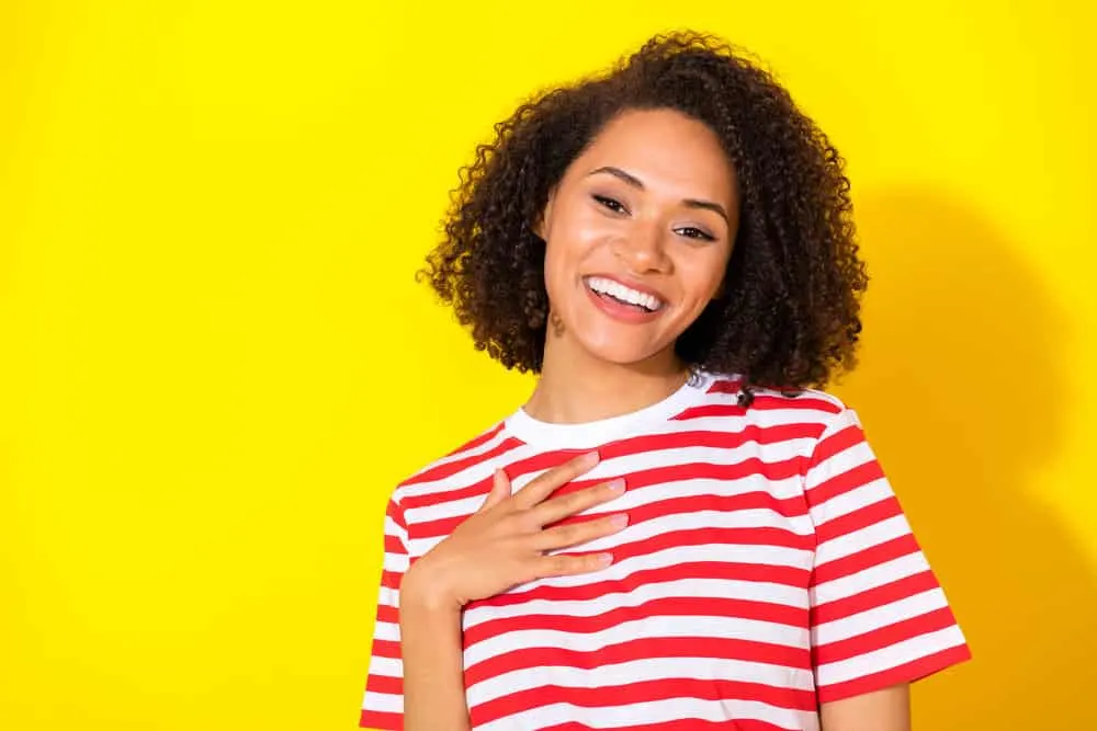 A girl with curly hair washed her hair with a quarter-sized amount of high-lathering sulfate-free shampoo.