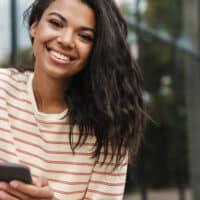 A black woman wearing a flat iron hairstyle after using a heat protectant on her naturally wavy texture.