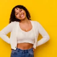 A young mixed-race female with loose curls and 3B hair texture is wearing a hair texturizer to achieve frizz-free curls.