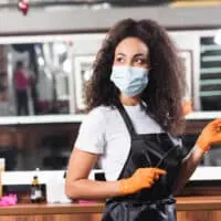 A light-skinned black lady with healthy hair gives women's haircuts and men's haircuts by appointment at a local salon.