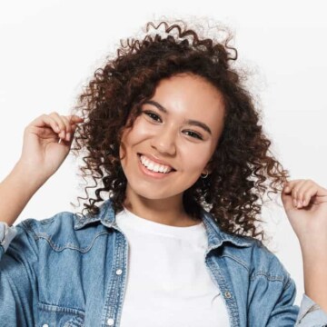 A beautiful young black female with shorter layers as her hair grows out following a layered cut to add volume.