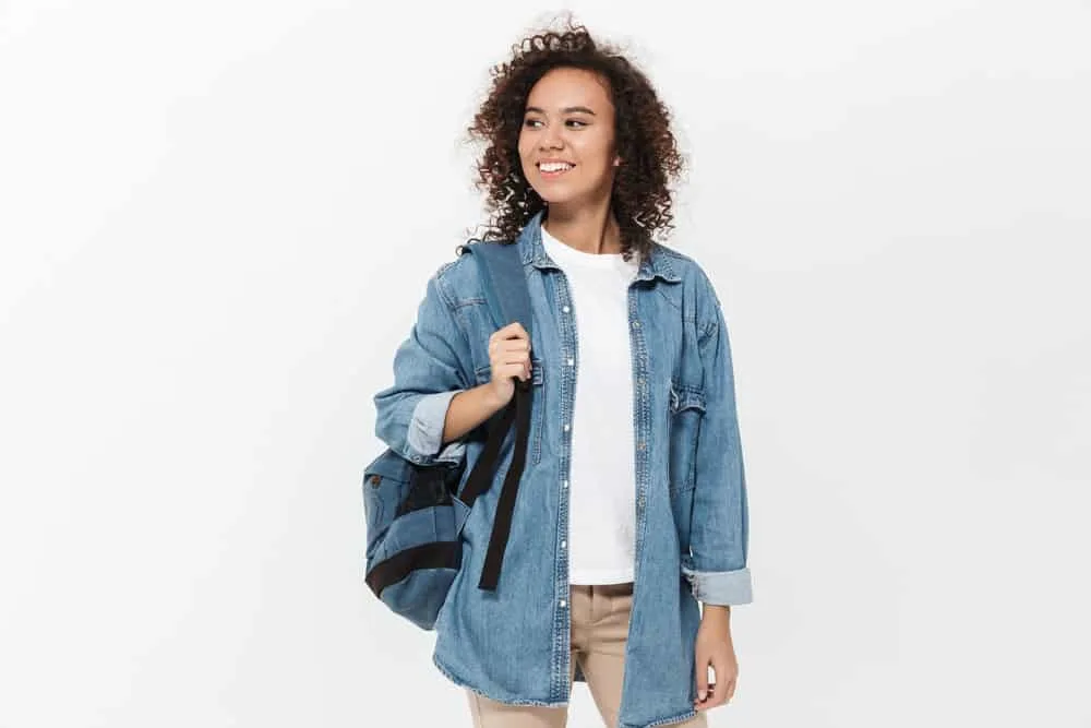 An excited young female went outside to dry her damp hair without a blow dry or heat-related technique.