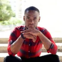 Young African American man with naturally type 4 curly locks wearing a high skin fade haircut