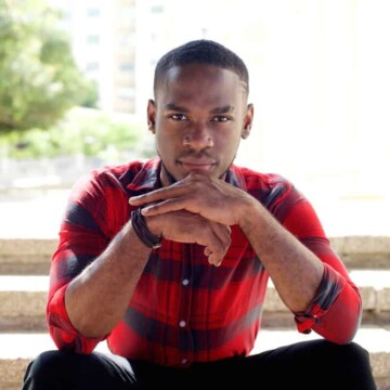 Young African American man with naturally type 4 curly locks wearing a high skin fade haircut