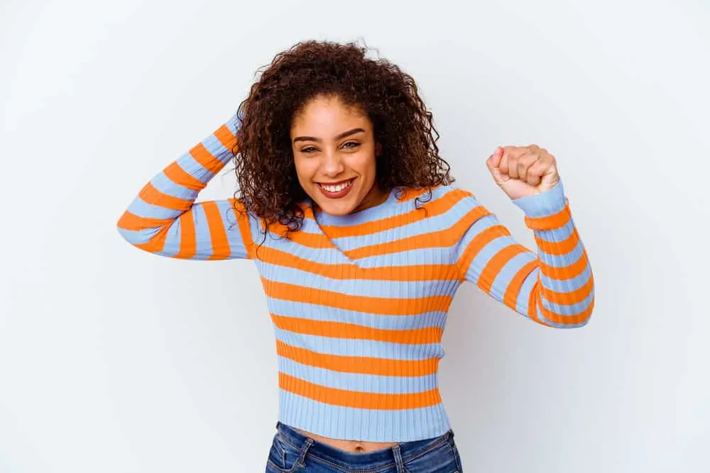 A happy female with light brown hair experienced hair cortex damaged from the chemical process.