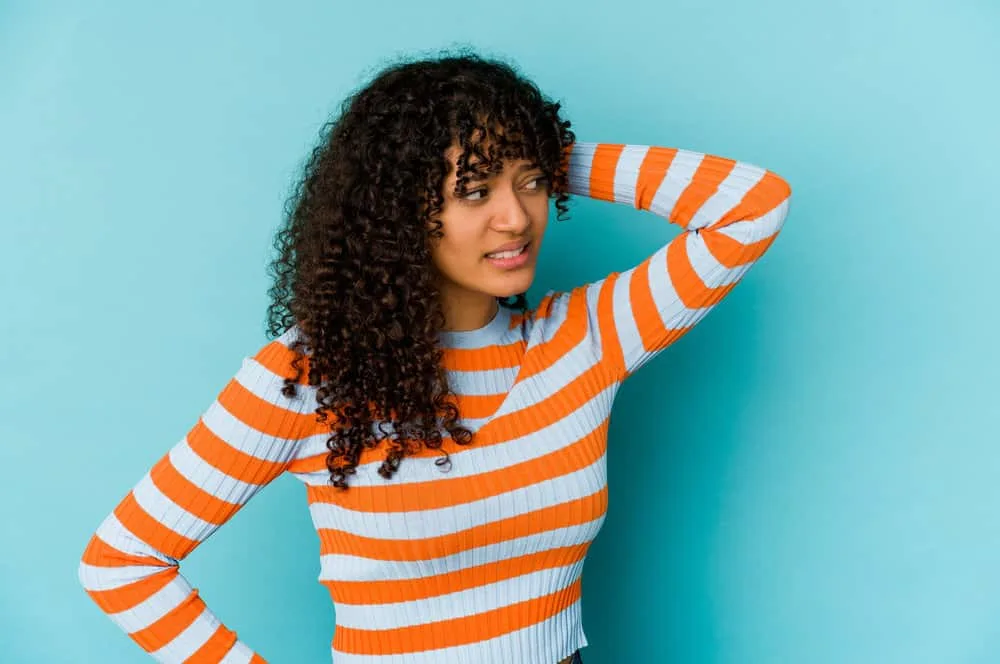 A lady with curly hair follicles washed with a medicated shampoo and styled with tea tree oil and other essential oils.