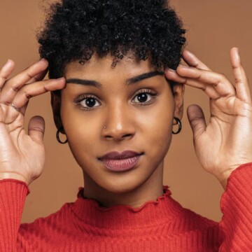 A cute black lady with an itchy scalp has been using an anti-dandruff shampoo with original therapeutic formula.