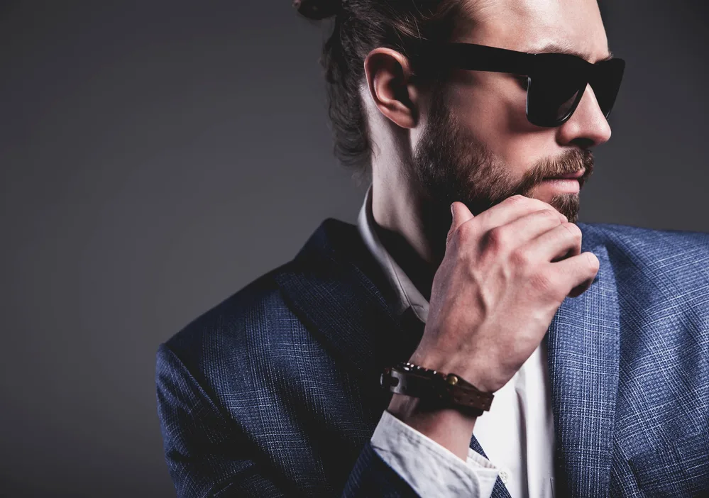 White male with a basic man bun (i.e., messy bun) secured with a hair band and styled with a leave-in conditioner.