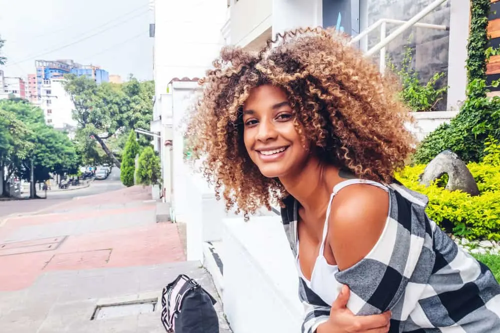 A light-skinned black girl with fine hair in a medium-length, wash-n-go hairstyle after getting her hair trimmed.