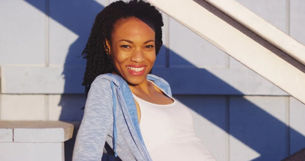 A black woman that's new to the Natural Hair Community wearing a twist-out style where her hair resembles dreads.