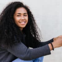 A young black girl with a type 3 hair texture has curly and wavy hair due to her unique natural curl pattern.