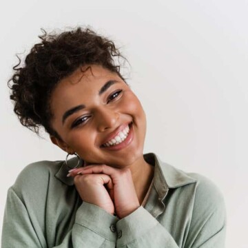 A happy young black girl used makeup remover to gently rub leftover hair dye off her skin quickly.