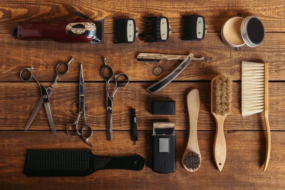 A set of equipment at a local barbershop showing clippers with a ceramic blade, a honing stone, and new blades.