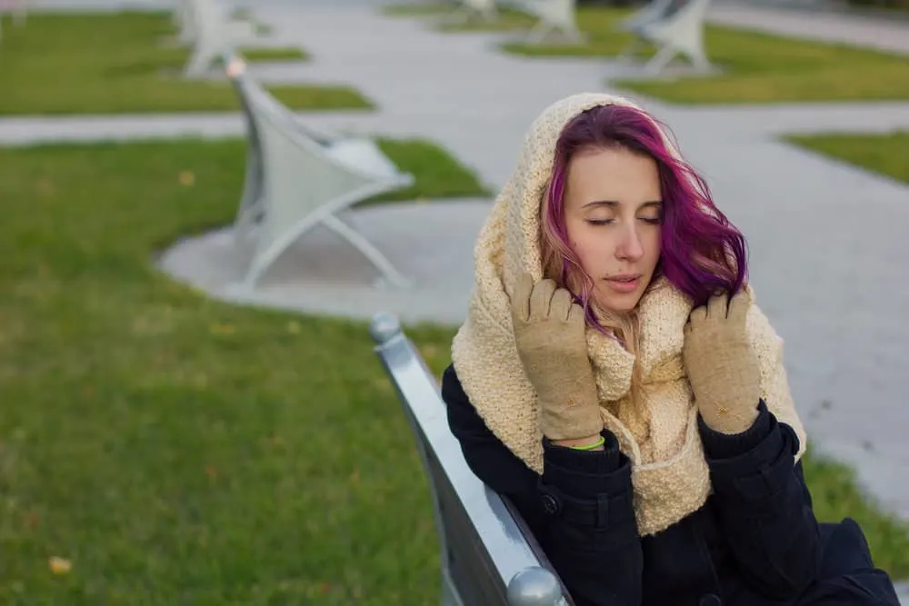 A woman with recently dyed hair after just removing hair dye off skin by using liquid detergent to treat the stained areas.