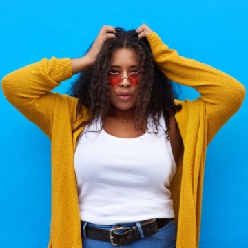 A black girl with kinky hair follicles after using a rosemary hair rinse to stimulate hair growth on her thinning hair.