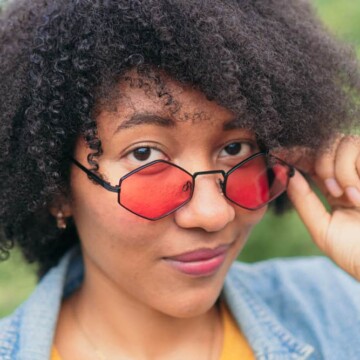 African American female with natural curls treated with bentonite clay hair mask to fix her dry hair cuticles.