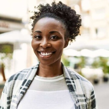 African American female with dark hair after using conventional hair dye to make her brown hair a deep black color.