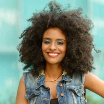 A cute African American female with highly porous hair strands on color-treated hair that won't absorb moisture.