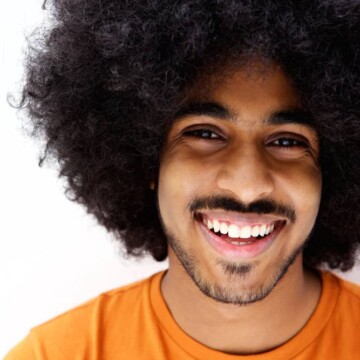 African American male with type 4 black hair uses natural oils and avoids harsh chemicals to encourage hair growth.