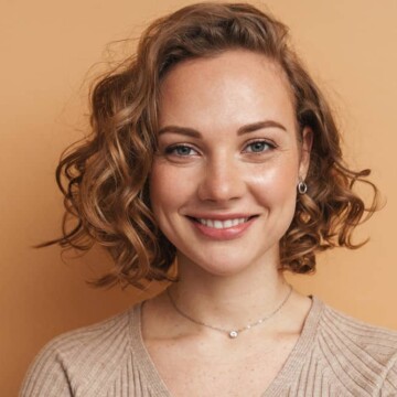 A young white female with medium-length layered hair with beautiful swoopy layers and wispy bangs.