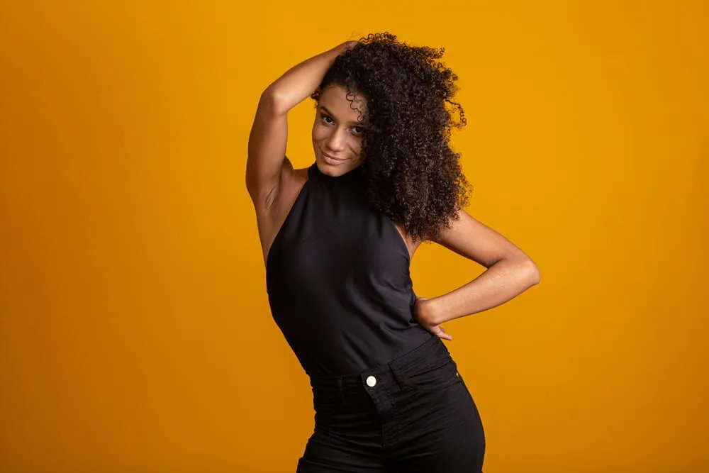 A stunning black woman with voluminous, bouncy, mid-length curls on a traditional shaggy bob haircut style.