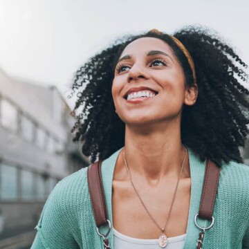 A woman's natural hair is styled with natural oils after co-washing hair with cleansing conditioners (i.e., only conditioner).