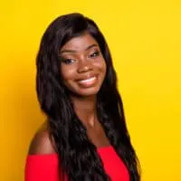 A cute black girl wearing a human hair wig secured by a thin line of wig glue protecting her sensitive skin.