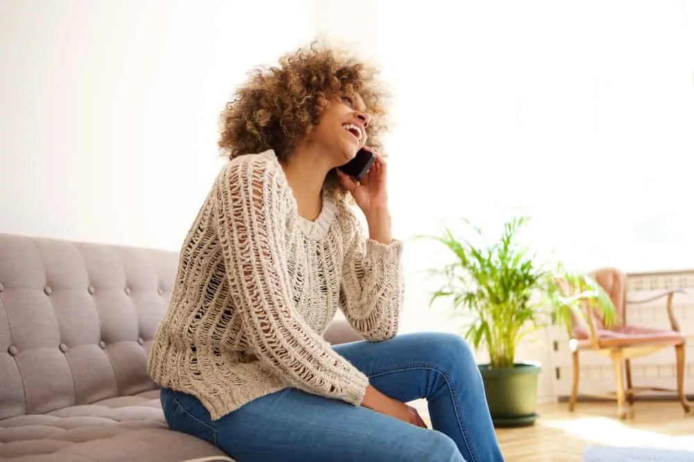 A light-skinned African American female is talking to a friend on the phone about hairstyles that signify black culture and style.