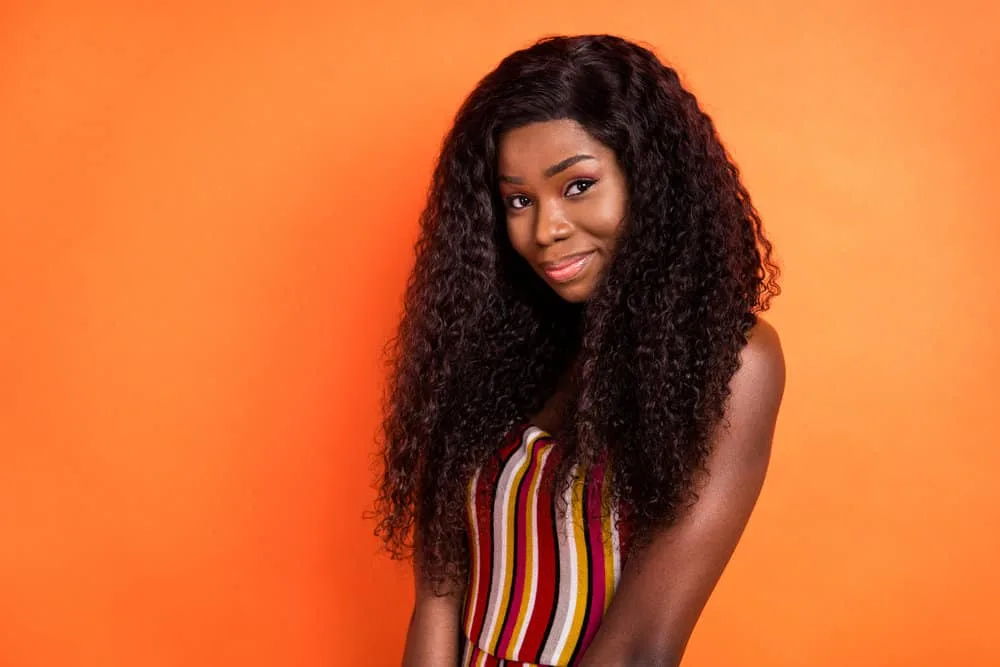 A cute African lady wearing a dark brown fuller wig with a casual summer time outfit.