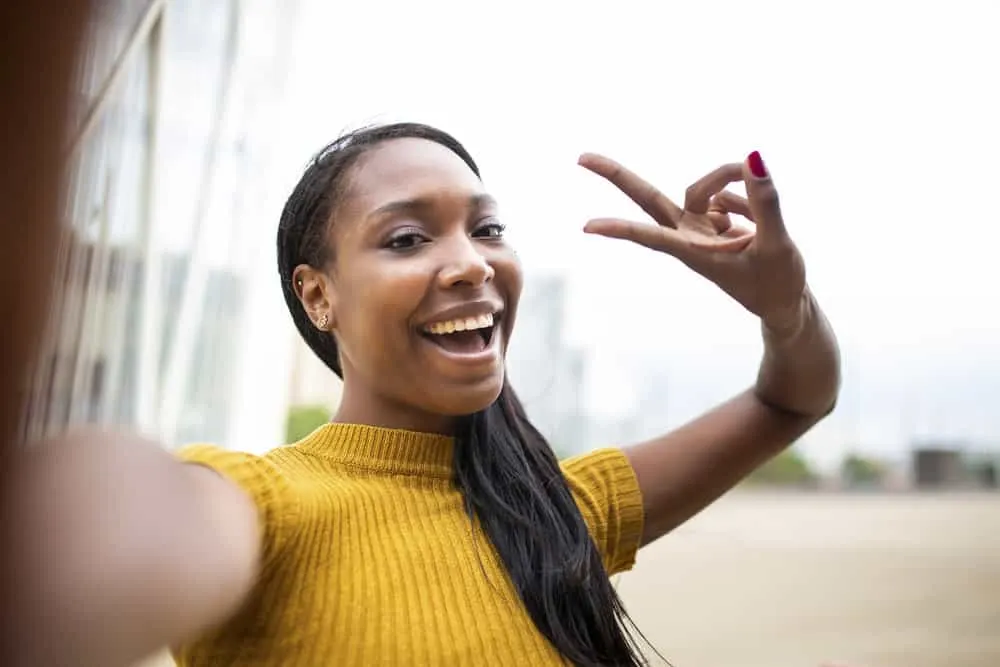 A gorgeous woman with flat ironed hair uses curly hair products and protective styles during her hair regimen.