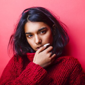 A young, pretty Indian girl with silky hair used natural hair oils, like coconut oil, to encourage healthy hair growth.