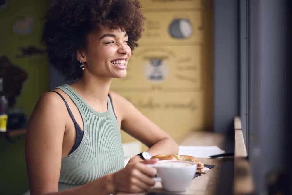 A cute black reading an article about how a standardized scalp massage promotes hair growth.