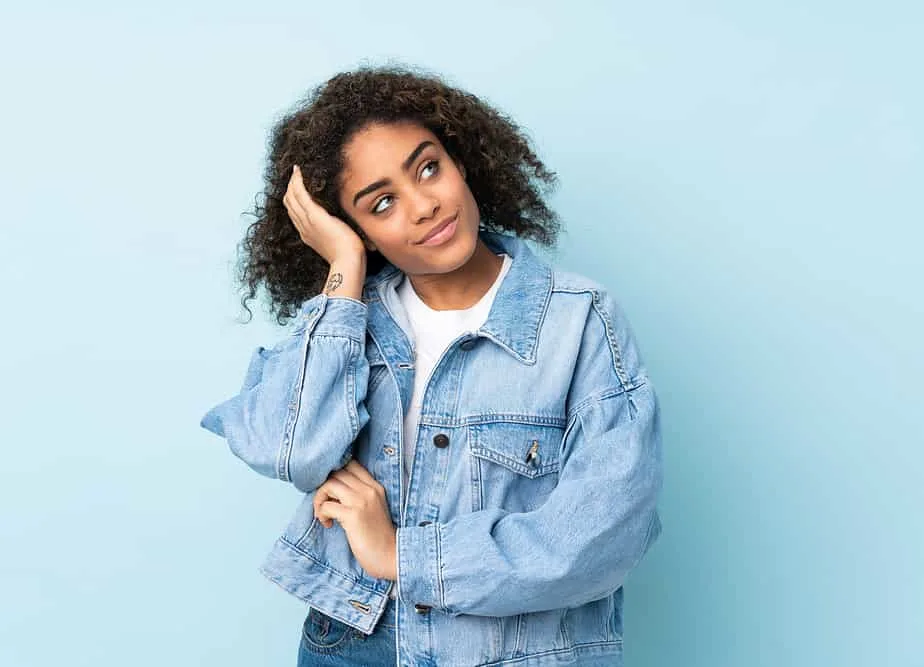 A beautiful young black woman uses the Curly Girl Method to promote hair growth.