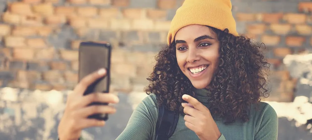 A beautiful black girl with hair shaft damage takes a selfie of her detangled hair strands.