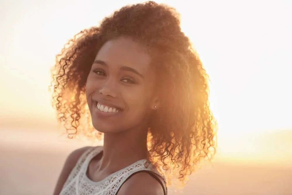 A lady with improved hair health after her hair was breaking off from using excessive heat damage.