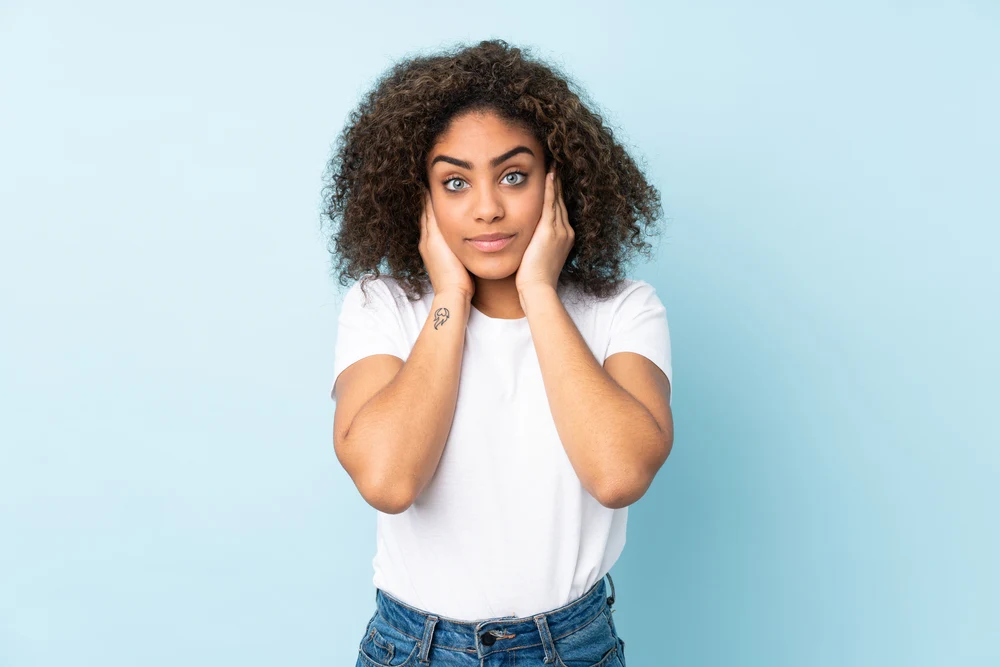 A black woman with naturally curly hair styled with tea tree oil and rosemary essential oil.