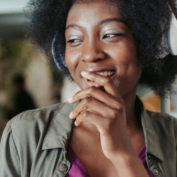 A cute black girl with a tight curl pattern on her 4C natural hair used coconut oil to retain moisture.