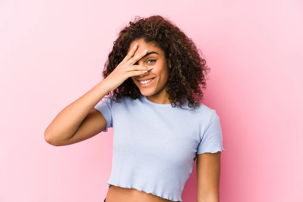 A black girl uses a mixture of rosemary oil and ylang-ylang oil to regulate dryness.