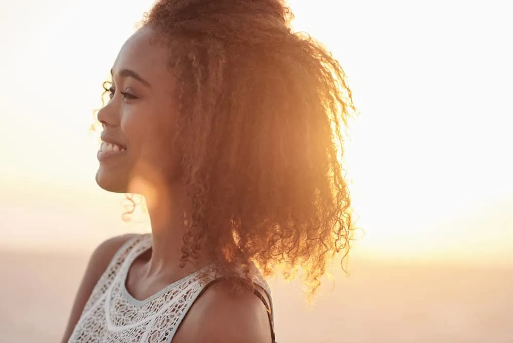 A female with greasy hair is trying to determine whether an unhealthy diet leads to dry or brittle hair.