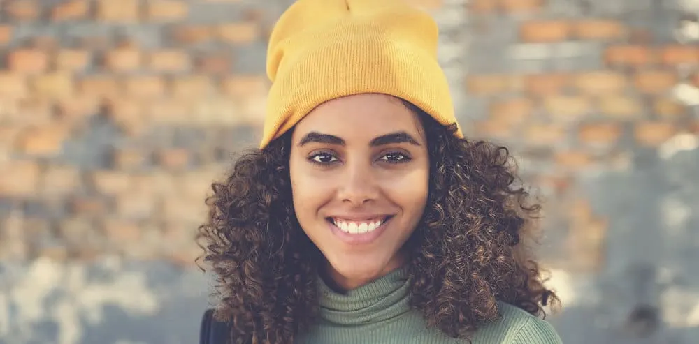 A cute Latin American female with long hair that's about half an inch past her shoulder.