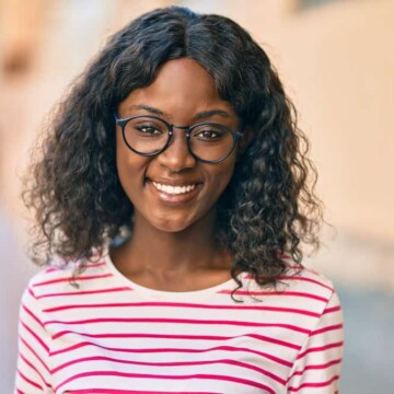 A young African American female with naturally thin hair wearing a lower-density wig made from synthetic hair.