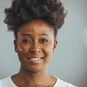 A black woman with 4C natural hair strands styled with a leave-in conditioner to retain moisture.