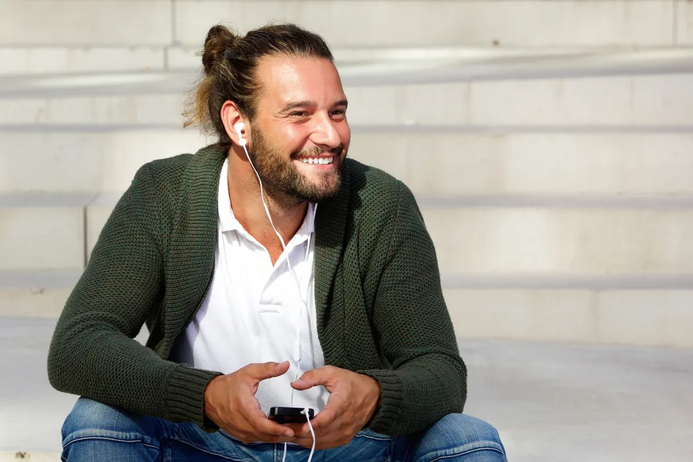 With a few tips, he achieves the perfect bun shape, showcasing his skill in styling his own hair.