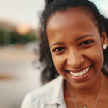 A young black female with a wavy natural curl pattern used the Curly Girl Method to make her wavy hair curlier and keep her defined curls hydrated.