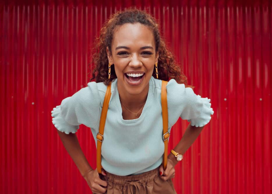 A cute black girl with natural curls on a type 3 hair texture styled with natural oils in a loose ponytail hairstyle that's perfect for her greasy hair.