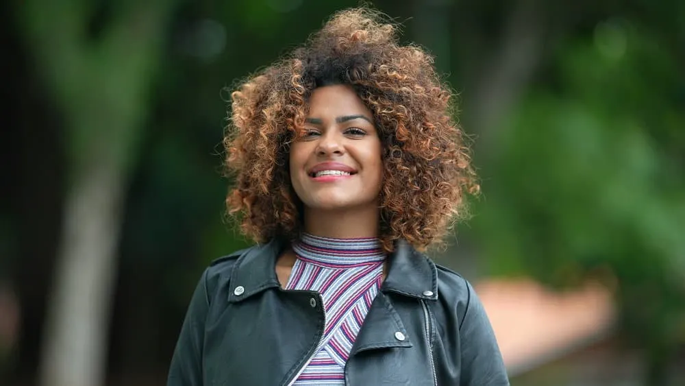 A black female with light skin showcases her colored hair with cool shades of blonde and crazy colors for a bold and daring look.