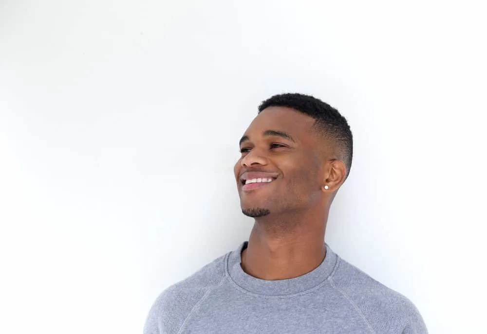 Whether he's trimming wet or dry hair, this black man knows how to get the job done with his powerful cordless clippers and adjustable blades, showcasing his expertise in hair trimming and his ability to adapt to different hair textures.