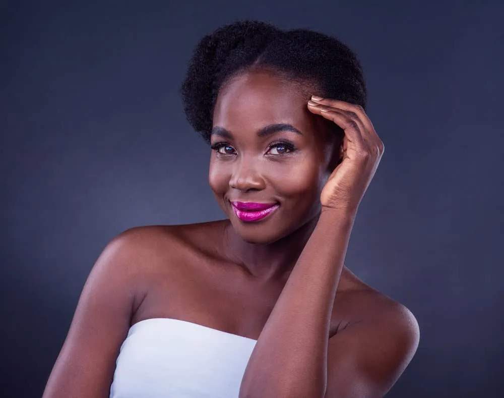 A gorgeous black girl with type 4 natural hair showcases the importance of sealing moisture in the hair shaft with light sealing oils, like olive or peppermint oil.