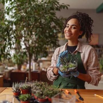 A young African American woman with an aloe vera plant that she'll use to promote hair growth and smooth an irritated scalp.